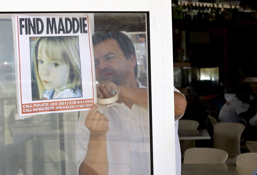 A waiter hangs a picture of missing 3-year-old girl Madeleine McCann on a restaurant&#39;s window, Thursday, May 10 2007, in Praia da Luz, southern Portugal. (AP Photo/Armando Franca, File)