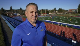 Joe Kennedy, a former assistant football coach at Bremerton High School in Bremerton, Wash., poses for a photo March 9, 2022, at the school&#39;s football field. After losing his coaching job for refusing to stop kneeling in prayer with players and spectators on the field immediately after football games, Kennedy will take his arguments before the U.S. Supreme Court on Monday, April 25, 2022, saying the Bremerton School District violated his First Amendment rights by refusing to let him continue praying at midfield after games. (AP Photo/Ted S. Warren)