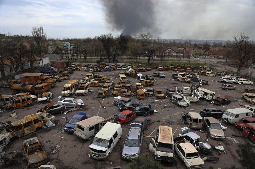 Damaged and burned vehicles are seen at a destroyed part of the Illich Iron &amp;amp; Steel Works Metallurgical Plant, as smoke rises from the Metallurgical Combine Azovstal during heavy fighting, in an area controlled by Russian-backed separatist forces in Mariupol, Ukraine, Monday, April 18, 2022. (AP Photo/Alexei Alexandrov, File)