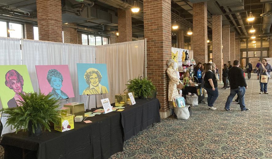 Attendees walk around a vendors' market at the first ever "The Golden Girls" fan convention Friday, April 22, 2022, at the Navy Pier in Chicago. Golden-Con, which lasts thru Sunday, is giving those who adored the NBC sitcom a chance to mingle, see panels and buy merchandise. The show, which ran from 1985-1992, starred Bea Arthur, Rue McClanahan, Estelle Getty and Betty White—who died at age 99 in December. (AP Photo/Terry Tang)