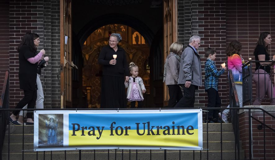 Parishioners walk in procession around the church, Friday, April 22, 2022, during a Good Friday service at St. Mary's Ukrainian Orthodox Cathedral in Allentown, Pa.. While Easter is the most joyous of holy days on the church calendar, marking the day Christians believe Jesus triumphed over death, many members of Ukrainian Orthodox churches across the United States are finding it difficult to summon joy at a time of war. (AP Photo/Wong Maye-E)