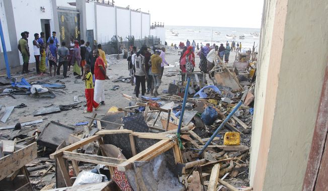 People look at destroyed shops in Mogadishu&#x27;s Lido beach, Somalia, Saturday, April, 23, 2022, after a bomb blast by Somalia’s Islamic extremist rebels hit a popular seaside restaurant killing at least six people. Ambulance service officials say the explosion occurred Friday evening when many patrons gathered for an Iftar meal to break the Ramadan fast. (AP Photo/Farah Abdi Warsameh) ** FILE **