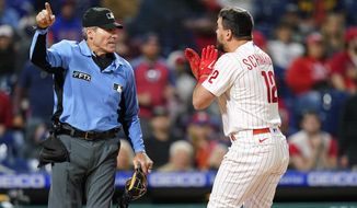 Philadelphia Phillies&#x27; Kyle Schwarber, right, reacts to umpire Angel Hernandez after striking out during the ninth inning of a baseball game against the Milwaukee Brewers, Sunday, April 24, 2022, in Philadelphia. (AP Photo/Matt Slocum)