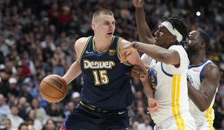 Denver Nuggets center Nikola Jokic, left, looks to pass the ball as Golden State Warriors center Kevon Looney, center, and forward Draymond Green defend in the second half of Game 4 of an NBA basketball first-round Western Conference playoff series Sunday, April 24, 2022, in Denver. (AP Photo/David Zalubowski)