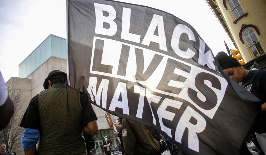 David Brown carries a Black Lives Matter flag during a march through downtown Grand Rapids, Mich., on Saturday, April 23, 2022. The march, which was organized by the Breonna Taylor Foundation, began at Veterans Park in response to the shooting death of Patrick Lyoya by a Grand Rapids police officer on April 4. (Daniel Shular/The Grand Rapids Press via AP)