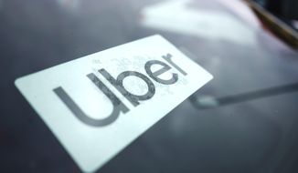 An Uber sign is displayed inside a car in Palatine, Ill., United States, Feb. 10, 2022. Uber had agreed to pay a 26 million Australian dollar ($19 million) fine for misleading riders by falsely warning they could be charged a cancellation fee and for inflating estimates of what a taxi would cost for the same journey, Australia’s consumer watchdog said on Tuesday, April 26, 2022. (AP Photo/Nam Y. Huh, File)
