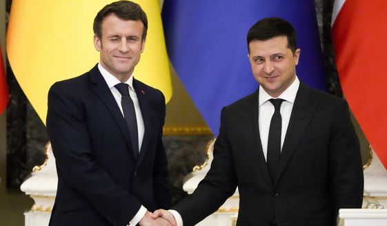 French President Emmanuel Macron, left, winks as he shakes hands with Ukrainian President Volodymyr Zelenskyy after a joint news conference following their talks in Kyiv, Ukraine, Tuesday, Feb. 8, 2022. (AP Photo/Efrem Lukatsky, File)