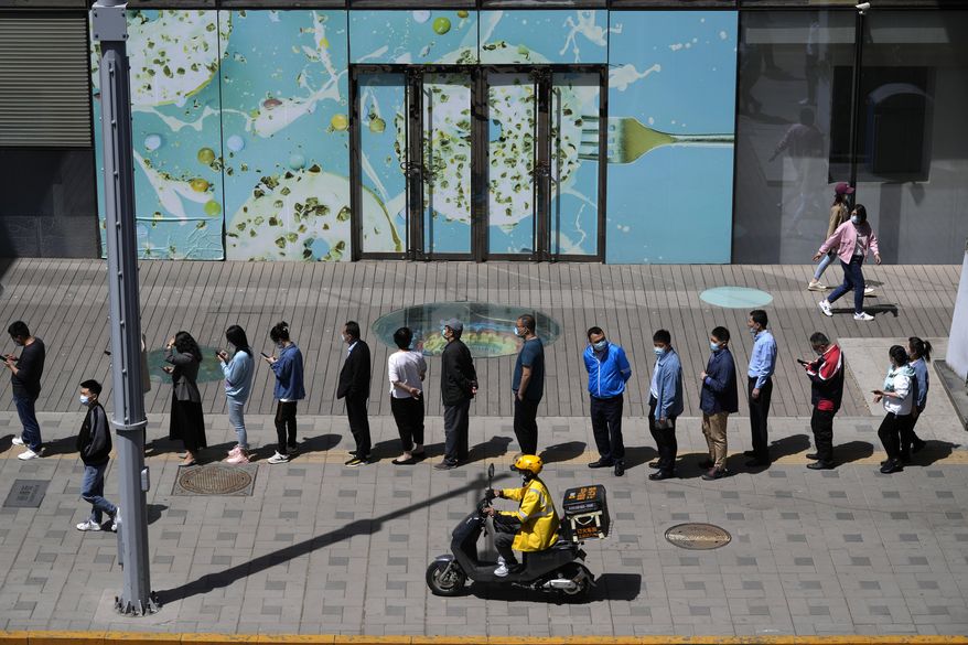 Residents line up for COVID mass testing in the Haidian district on Tuesday, April 26, 2022, in Beijing. China's capital Beijing is enforcing mass testing and closing down access to neighborhoods as it seeks to contain a new COVID-19 outbreak. (AP Photo/Ng Han Guan)