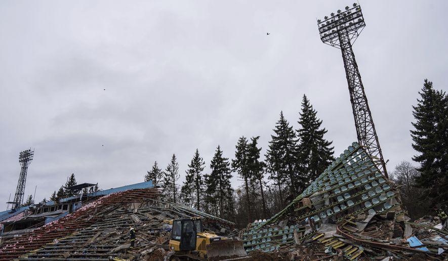 A bulldozer works at a central stadium damaged by Russian forces&#39; shelling in Chernihiv, Ukraine, Wednesday, April 13, 2022. (AP Photo/Evgeniy Maloletka)
