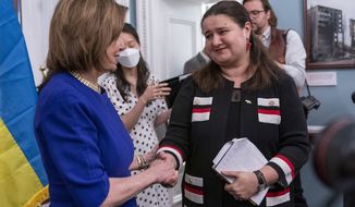 Speaker of the House Nancy Pelosi of Calif., left, shakes hands with Ukrainian Ambassador Oksana Markarova, during an event unveiling a photography exhibit about the war in Ukraine, Thursday, April 28, 2022, at the Capitol in Washington. (AP Photo/Jacquelyn Martin)