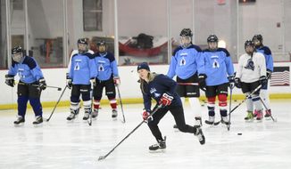 U.S. hockey player Haley Skarupa, front, demonstrates a drill during a hockey clinic presented by the Washington Capitals and the Professional Women&#39;s Hockey Players Association, Friday, March 4, 2022, in Arlington, Va. The growth of girls and women&#39;s hockey in the Washington area is still a work in progress almost two decades into a boom of youth participation in the sport credited to Alex Ovechkin and the NHL&#39;s Capitals.(AP Photo/Nick Wass). **FILE**