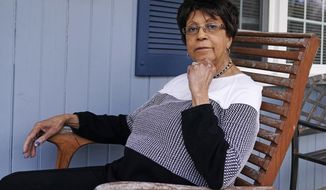 Roberta Wolff, a descendant of Tony, Cuba and Darby Vassall who were enslaved by Harvard benefactors in the institution&#39;s first decades, poses on the front porch of her family home, Wednesday, April 27, 2022, in Bellingham, Mass. In Harvard&#39;s pledge to atone for its ties to slavery, it identified dozens of people who were enslaved by the university&#39;s first leaders and faculty members. Hundreds of years later, their living descendants are estimated to number in the thousands, including some who lived and worked in the Boston area without knowing their family connection to the Ivy League school. (AP Photo/Charles Krupa)