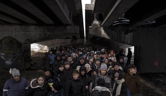FILE - People crowd under a destroyed bridge as they try to flee, crossing the Irpin river on the outskirts of Kyiv, Ukraine, Tuesday, March 8, 2022. Russia&#39;s relentless digital assaults on Ukraine may have caused less damage than many anticipated. But most of its hacking is focused on a different goal that gets less attention but has chilling potential consequences: data collection. (AP Photo/Felipe Dana, File)