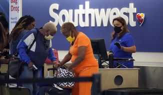 Travelers line up at a Southwest Airlines ticket counter at Los Angeles International Airport Monday, April 25, 2022, in Los Angeles. A week earlier, a federal judge in Florida struck down the requirement to wear a mask in airports and during flights. That rule, designed to limit the spread of COVID-19, was due to expire anyway on May 3. (AP Photo/Marcio Jose Sanchez)