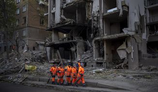 Clean-up crews prepare to work at the site of an explosion in Kyiv, Ukraine on Friday, April 29, 2022. Russia struck the Ukrainian capital of Kyiv shortly after a meeting between President Volodymyr Zelenskyy and U.N. Secretary-General António Guterres on Thursday evening. (AP Photo/Emilio Morenatti)