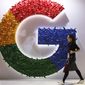 A woman walks past the logo for Google at the China International Import Expo in Shanghai on Nov. 5, 2018.  (AP Photo/Ng Han Guan, File)