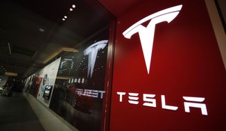 FILE - A sign bearing the company logo outside a Tesla store in Cherry Creek Mall in Denver, Feb. 9, 2019. Elon Musk has sold 4.4 million shares of  Tesla stock worth roughly $4 billion, most likely to help fund his purchase of Twitter. (AP Photo/David Zalubowski, File)