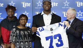Dallas Cowboys first-round NFL football draft pick Tyler Smith, second from right, of Tulsa, poses for a photo with his brother Isaac, left, and mother Patricia,  second from left, and team owner Jerry Jones, right, during a news conference in Frisco, Texas, Friday, April 29, 2022. (Shafkat Anowar/The Dallas Morning News via AP)