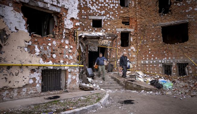 Oleksiy Onoschenko, 42, rescues books from his house destroyed during the Russian occupation in Irpin, in the outskirt of Kyiv, Ukraine on Saturday, April 30, 2022. (AP Photo/Emilio Morenatti)