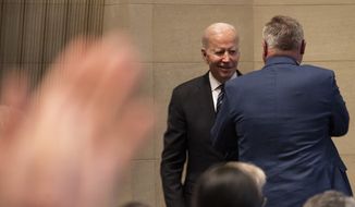 President Joe Biden shakes hands with Ted Mondale, right, at the memorial service for his father, former Vice President Walter Mondale, Sunday, May 1, 2022, after Biden spoke about the former vice president at the University of Minnesota in Minneapolis. (AP Photo/Jacquelyn Martin)
