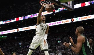 Milwaukee Bucks forward Giannis Antetokounmpo (34), of Greece, dunks as Boston Celtics guard Marcus Smart, left, and center Al Horford, right, look on in the first half of Game 1 in the second round of the NBA Eastern Conference playoff series, Sunday, May 1, 2022, in Boston. (AP Photo/Steven Senne)