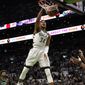 Milwaukee Bucks forward Giannis Antetokounmpo (34), of Greece, dunks as Boston Celtics guard Marcus Smart, left, and center Al Horford, right, look on in the first half of Game 1 in the second round of the NBA Eastern Conference playoff series, Sunday, May 1, 2022, in Boston. (AP Photo/Steven Senne)