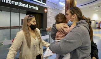 Families embrace after a flight from Los Angeles arrived at Auckland International Airport as New Zealand&#39;s border opened for visa-waiver countries Monday, May 2, 2022. New Zealand welcomed tourists from the U.S., Canada, Britain, Japan and more than 50 other countries for the first time in more than two years as it dropped most of its remaining pandemic border restrictions. (Jed Bradley/New Zealand Herald via AP)
