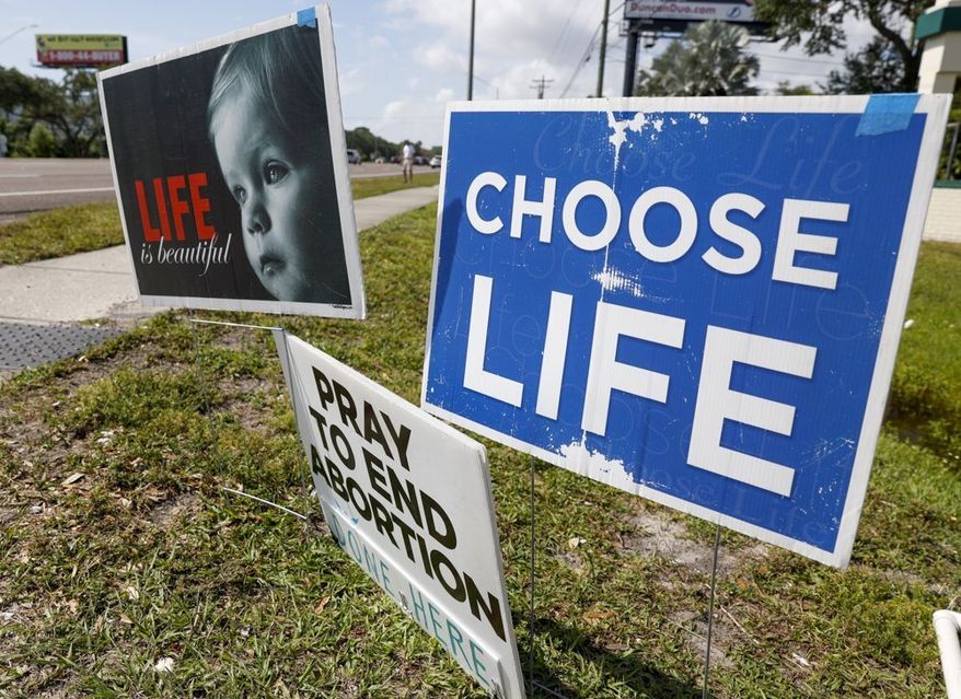 Pro life signs are seen outside the All Women&#x27;s Health Center of Clearwater on Tuesday, May 3, 2022. A draft of a U.S. Supreme Court brief was leaked Monday that suggests the court could be poised to overturn the landmark 1973 Roe v. Wade case. (Chris Urso/Tampa Bay Times via AP)