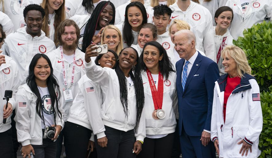 President Joe Biden and first lady Jill Biden take photographs with members of Team USA during an event with the Tokyo 2020 Summer Olympic and Paralympic Games, and Beijing 2022 Winter Olympic and Paralympic Games, on the South Lawn of the White House, Wednesday, May 4, 2022, in Washington. (AP Photo/Evan Vucci)