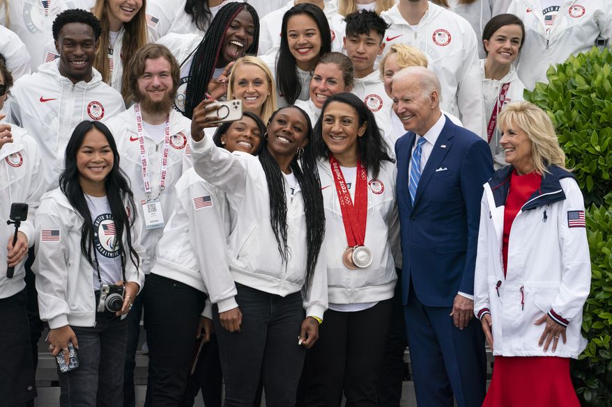 President Joe Biden and first lady Jill Biden take photographs with members of Team USA during an event with the Tokyo 2020 Summer Olympic and Paralympic Games, and Beijing 2022 Winter Olympic and Paralympic Games, on the South Lawn of the White House, Wednesday, May 4, 2022, in Washington. (AP Photo/Evan Vucci)