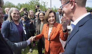 Speaker of the U.S. House of Representatives Nancy Pelosi touches the chin of U.S. Rep. Derek Kilmer as she thanks him following an Infrastructure Investment and Jobs Act press conference in front of the Chambers Creek Dam in University Place, Wash. on Wednesday, May 4, 2022. (Tony Overman/The News Tribune via AP)