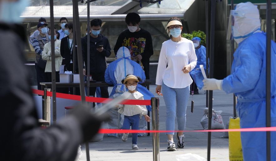 Residents line up for mass COVID-19 testing on Tuesday, May 3, 2022, in Beijing. China has stuck to its strict "zero-COVID" approach that restricts travel, mass tests entire cities and sets up sprawling temporary facilities to try to isolate every infected person. (AP Photo/Ng Han Guan)