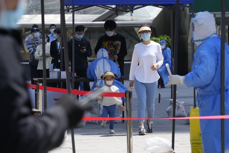 Residents line up for mass COVID-19 testing on Tuesday, May 3, 2022, in Beijing. China has stuck to its strict "zero-COVID" approach that restricts travel, mass tests entire cities and sets up sprawling temporary facilities to try to isolate every infected person. (AP Photo/Ng Han Guan)