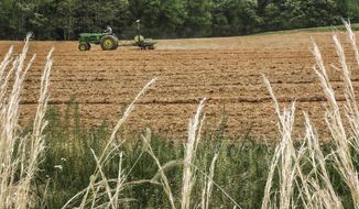 A farmer works in a field off of U.S. 60 Highway, Wednesday, May 4, 2022, in Owensboro, Ky. (Greg Eans/The Messenger-Inquirer via AP)
