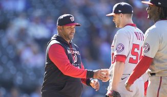 Washington Nationals manager Dave Martinez, left, takes the ball from relief pitcher Austin Voth as Voth is pulled from the mound after issuing a walk to Colorado Rockies&#39; Charlie Blackmon in the eighth inning of a baseball game Thursday, May 5, 2022, in Denver. (AP Photo/David Zalubowski)