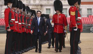 Britain&#39;s Prime Minister Boris Johnson, centre background, walks with Japan&#39;s Prime Minister Fumio Kishida as they review an Honour Guard, during a welcoming ceremony in Westminster, London, Thursday, May 5, 2022. The leaders of Britain and Japan met in London to announce a new defense agreement against the backdrop of the war in Ukraine.  (Dan Kitwood/Pool Photo via AP)