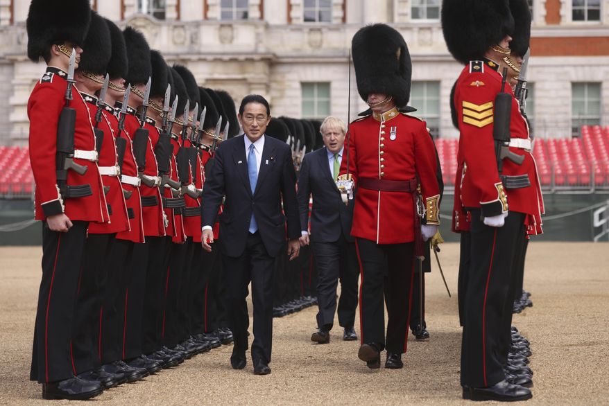 Britain&#x27;s Prime Minister Boris Johnson, centre background, walks with Japan&#x27;s Prime Minister Fumio Kishida as they review an Honour Guard, during a welcoming ceremony in Westminster, London, Thursday, May 5, 2022. The leaders of Britain and Japan met in London to announce a new defense agreement against the backdrop of the war in Ukraine.  (Dan Kitwood/Pool Photo via AP)