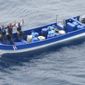 In this photo obtained from U.S. federal court records, Jeffri Dávila-Reyes, third from left, and two others hold their hands in the air as they are intercepted in the Caribbean Sea on Oct. 29, 2015. Dávila-Reyes says he’s still mystified how he ended up serving hard time in a U.S. federal prison. His cocaine bust at sea was closer to his homeland of Costa Rica than the United States, and the few kilos of drugs he was carrying were bound for Jamaica rather than American shores. (U.S. Coast Guard via AP)