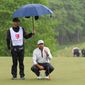 Jason Day looks over his putt with his caddie holding the umbrella over them during the 2nd round of the Wells Fargo Championship at TPC Potomac at Avenel Farm, Potomac, MD, May 6, 2022. (Photo by All-Pro Reels)