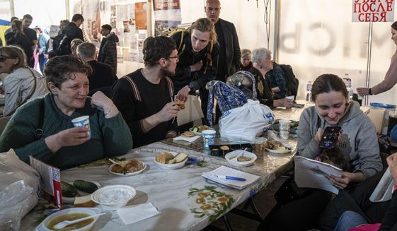 Members of the Tsybulchenko family have a meal with others after arriving from the Ukrainian city of Mariupol, at a center for displaced people in Zaporizhzhia, Ukraine, Tuesday, May 3, 2022. The family was among the first to emerge from the steel plant in a tense, days-long evacuation negotiated by the United Nations and the International Committee of the Red Cross with the governments of Russia, which now controls Mariupol, and Ukraine, which wants the city back. A brief cease-fire allowed more than 100 civilians to flee the plant. (AP Photo/Evgeniy Maloletka)