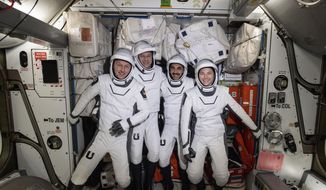In this photo made available by NASA, four commercial crew astronauts, from left, European Space Agency astronaut Matthias Maurer and NASA astronauts Tom Marshburn, Raja Chari and Kayla Barron pose for a photo in their Dragon spacesuits during a fit check aboard the International Space Station&#39;s Harmony module on April 21, 2022. SpaceX brought the four astronauts home with a splashdown in the Gulf of Mexico early Friday, May 6, capping the busiest month yet for Elon Musk’s taxi service. (NASA via AP)