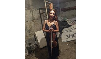 In this photo provided by violinist Vera Lytovchenko, she stands in a cellar with her violin in Kharkiv, Ukraine, on March 4, 2022. She performs in a new online video called &amp;quot;The Brave Ones&amp;quot; with other artists from various nations, including the U.S., South Africa, Japan and Canada, to raise money for humanitarian aid for musicians in Ukraine. (Vera Lytovchenko via AP)
