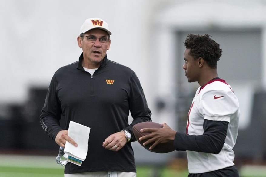 Washington Commanders head coach Ron Rivera, left, talks with wide receiver Jahan Dotson runs with the ball during Rookie Mini Camp practice at the team&#39;s NFL football training facility, Friday, May 6, 2022 in Ashburn, Va. (AP Photo/Alex Brandon)