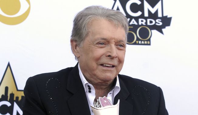 Mickey Gilley poses with the Triple Crown Award on the red carpet at the 50th annual Academy of Country Music Awards at AT&T Stadium in Arlington, Texas, on April 19, 2015. Gilley, whose namesake Texas honky-tonk inspired the 1980 film “Urban Cowboy,” and a nationwide wave of Western-themed nightspots, died Saturday, May 7, 2022, at age 86. (Photo by Jack Plunkett/Invision/AP, File)