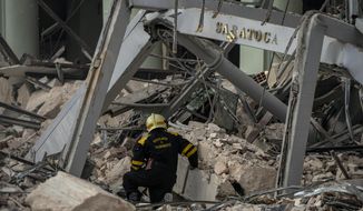 A member of a rescue team searches for survivors at the site of a deadly explosion that destroyed the five-star Hotel Saratoga, in Havana, Cuba, Friday, May 6, 2022. A powerful explosion apparently caused by a natural gas leak killed at least 18 people, including a pregnant woman and a child, and injured dozens Friday when it blew away outer walls from the luxury hotel in the heart of Cuba’s capital. (AP Photo/Ramon Espinosa)