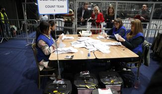 Election staff begin vote counting in Belfast in the Northern Ireland Assembly election early Friday in Belfast, Northern Ireland, Friday, May 6, 2022. In Northern Ireland, voters are electing a new 90-seat Assembly, with polls suggesting the Irish nationalist party Sinn Fein could win the largest number of seats, and the post of first minister, in what would be a historic first. (AP Photo/Peter Morrison)