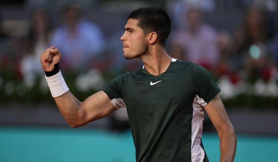 Carlos Alcaraz reacts after winning a point to Novak Djokovic during a men&#39;s semifinal at the Mutua Madrid Open tennis tournament in Madrid, Spain, Saturday, May 7, 2022. (AP Photo/Manu Fernandez)