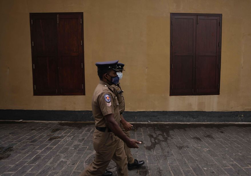 Sri Lankan police officers walk past a closed restaurant during a country wide strike in Colombo, Sri Lanka, Friday, May 6, 2022. Protesters have hung undergarments near Sri Lanka’s Parliament while shops, offices and schools closed and transport came to a near standstill amid nationwide demonstrations against the government over its alleged inability to resolve the worst economic crisis in decades. (AP Photo/Eranga Jayawardena)