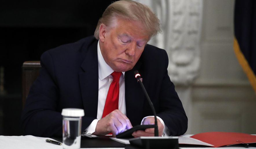 Then-President Donald Trump looks at his phone during a roundtable with governors on the reopening of America&#x27;s small businesses, in the State Dining Room of the White House in Washington, June 18, 2020. A San Francisco judge has rejected Trump&#x27;s lawsuit challenging his lifetime ban from Twitter. U.S. District Judge James Donato said in a ruling Friday, May 6, 2022, that Trump&#x27;s failed to show Twitter abridged his First Amendment right to free speech. (AP Photo/Alex Brandon) **FILE**