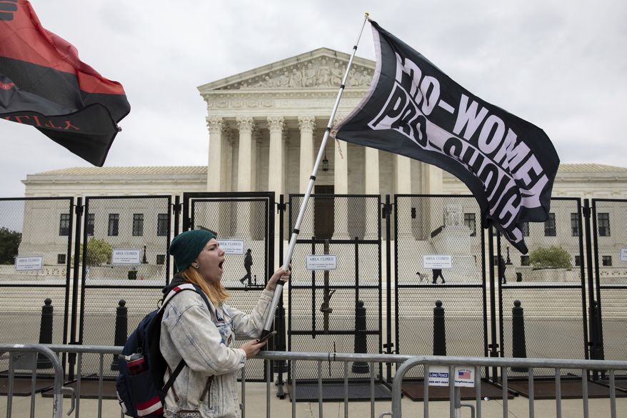 Abortion-rights protester Alex Cascio holds a flag during a demonstration outside of the U.S. Supreme Court in Washington, Sunday, May 8, 2022. (AP Photo/Amanda Andrade-Rhoades)
